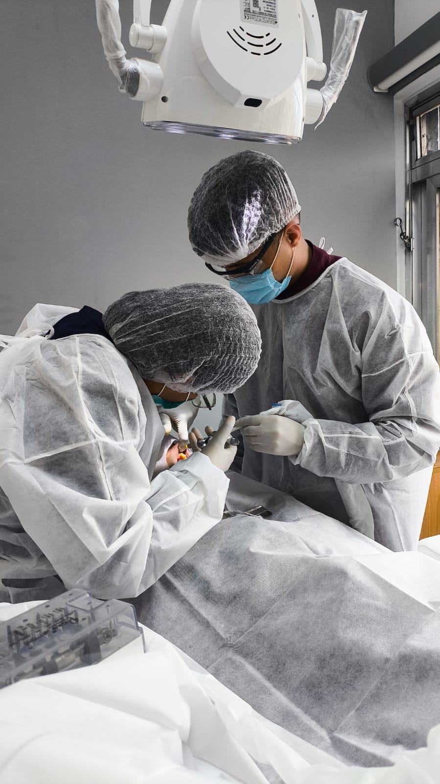 Dentista e seu Assitente realizando um tratamento.